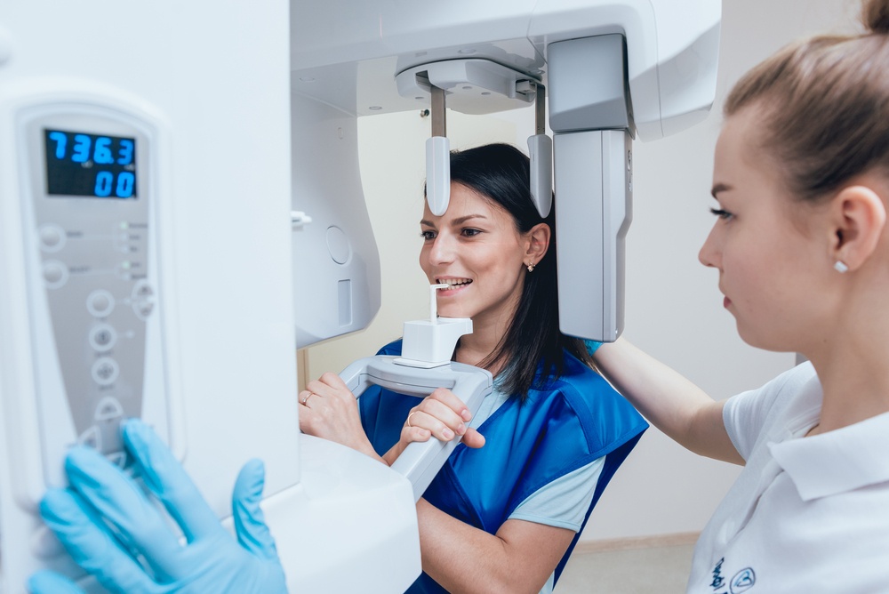 Young woman patient standing in x-ray machine. Panoramic radiography